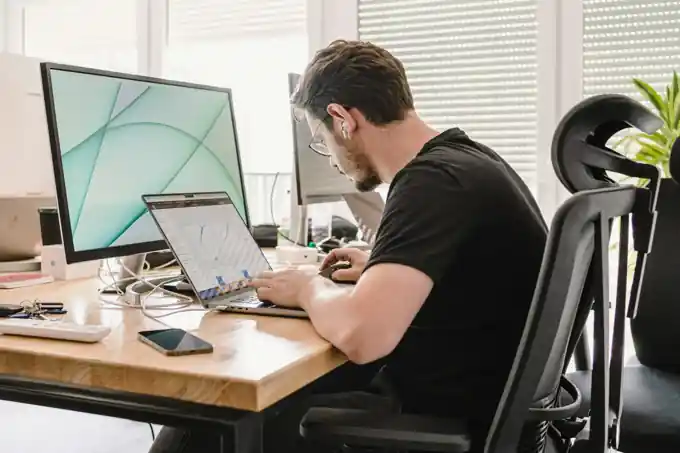 Creative professional working on a laptop in a bright workspace